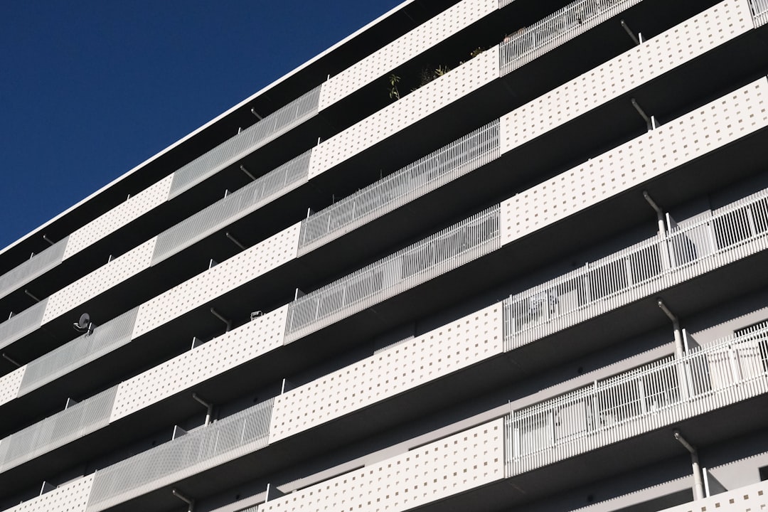 modern-apartment-building-with-balconies-against-blue-sky-jrncpvyw1k